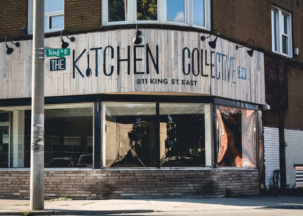 A storefront on the corner of an intersection with a sign that reads Kitchen Collective