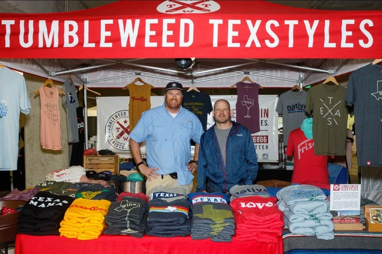 Jeb Matulich and Brian Wysiong standing within a Tumbleweed Texstyles booth for a pop-up event promoting the brand. 