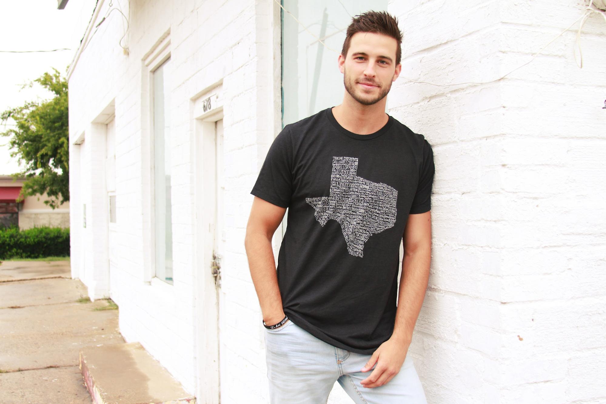 A male model in a black Tumbleweed Texstyles shirt.