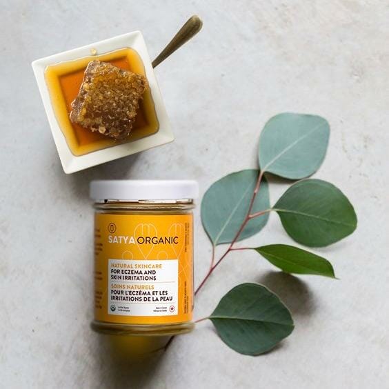 A jar of Sataya's product displayed with honeycomb. 