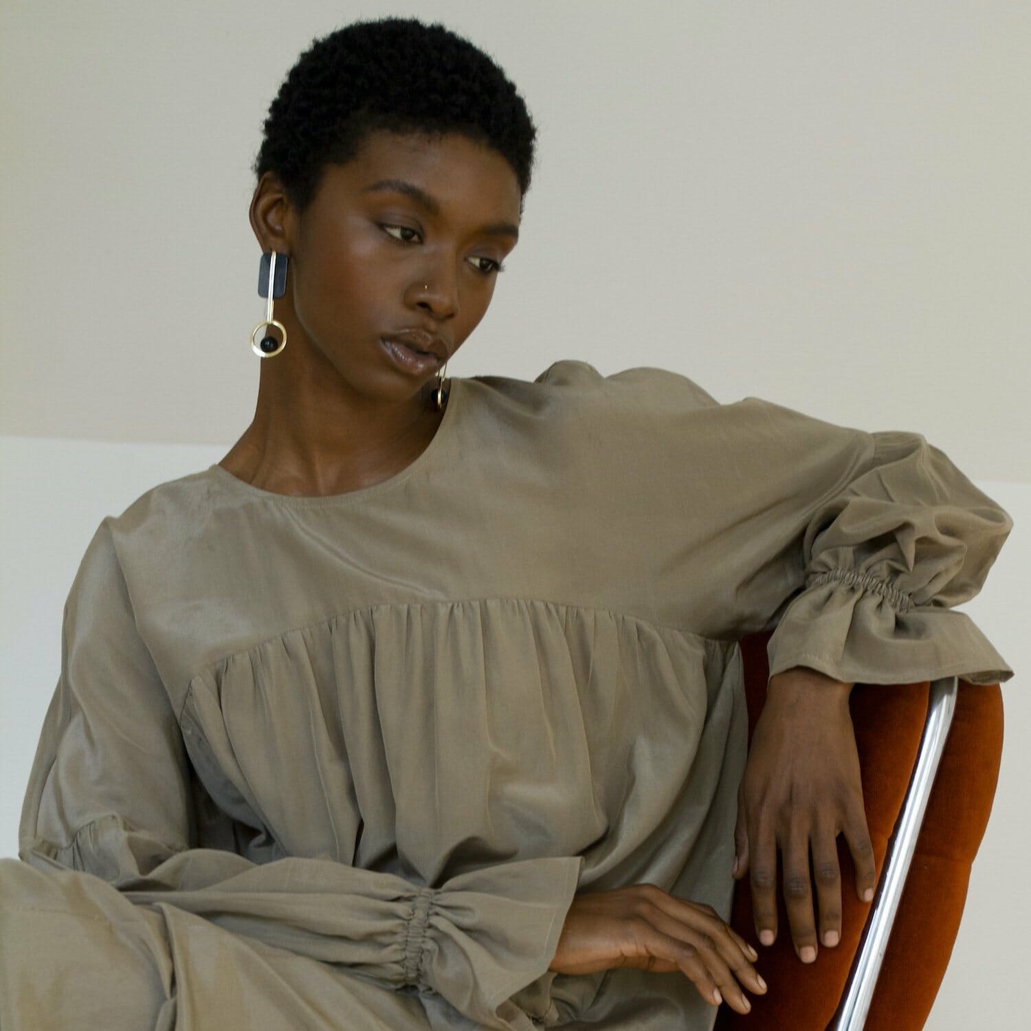 Model poses on a chair wearing a Selva Negra dress