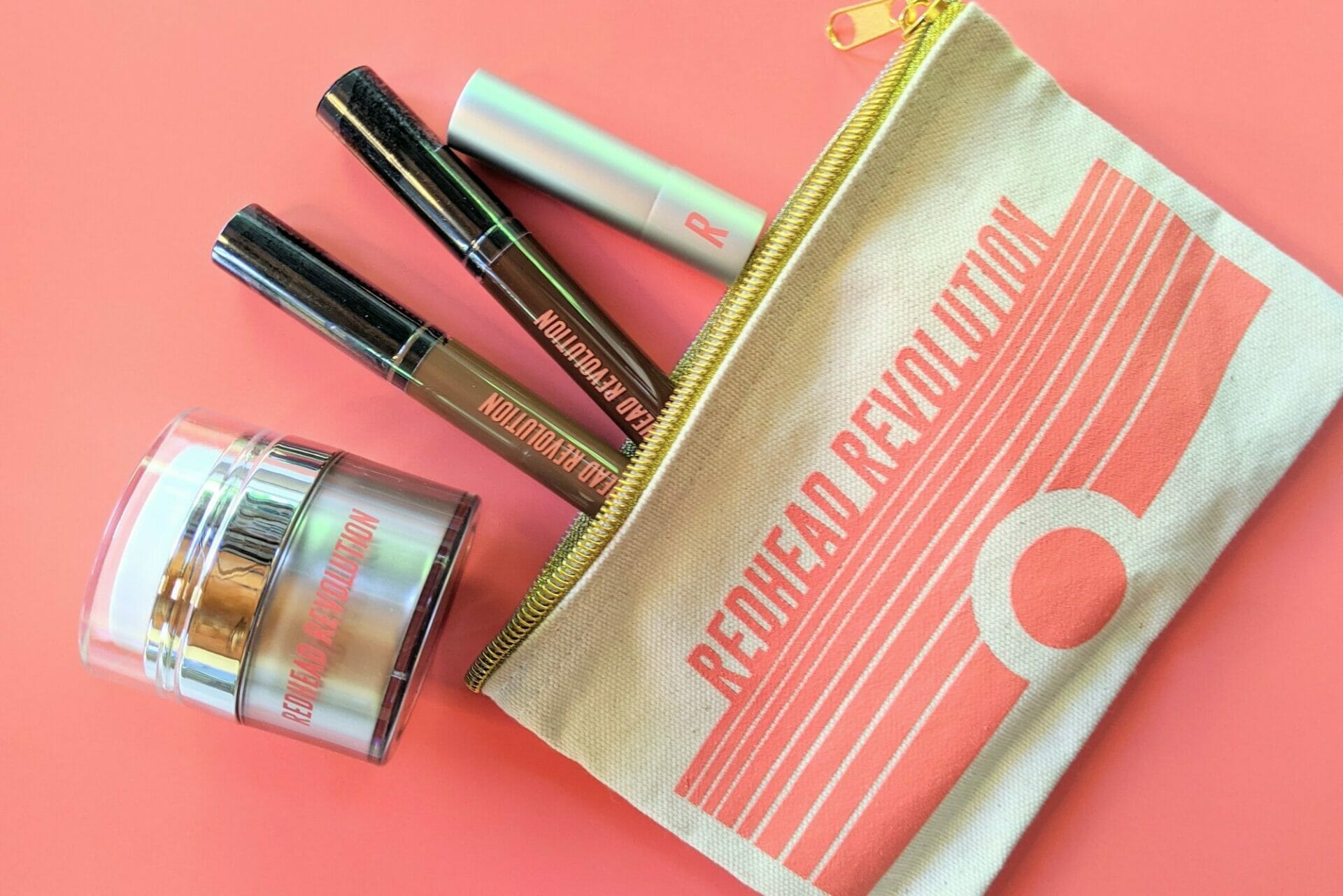 Cosmetic products spill out of a pouch that reads