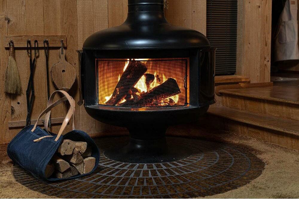 An indoor wood stove with a dire burning inside