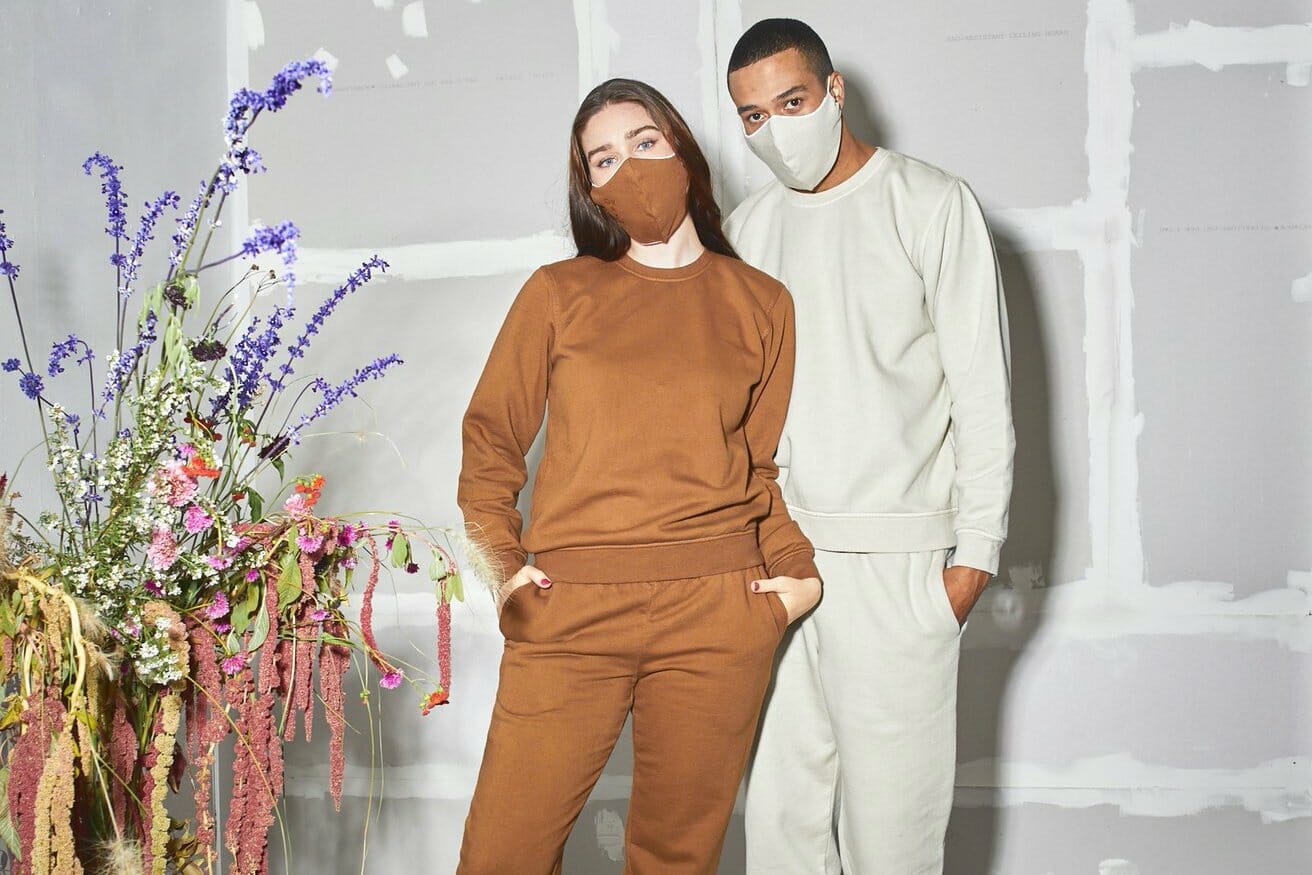 Two people model sweat suits and masks