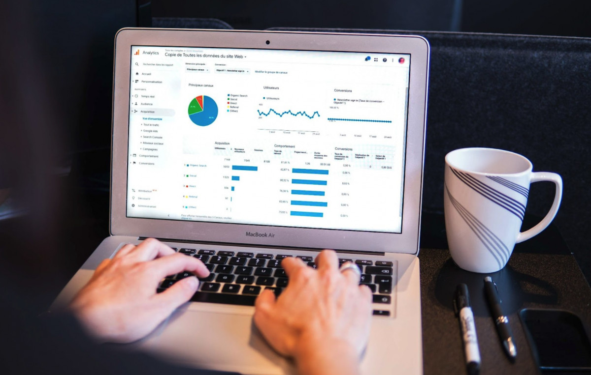 A person using a laptop with a graph on it for marketing analysis.