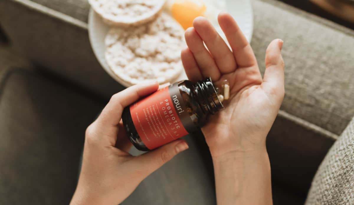 A hand holding a bottle of vitamin c in an online supplement business.