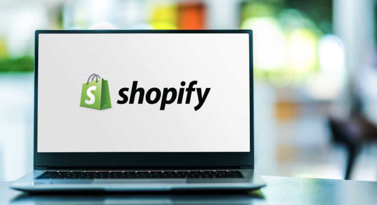 A marketing laptop with the shopify logo on it.