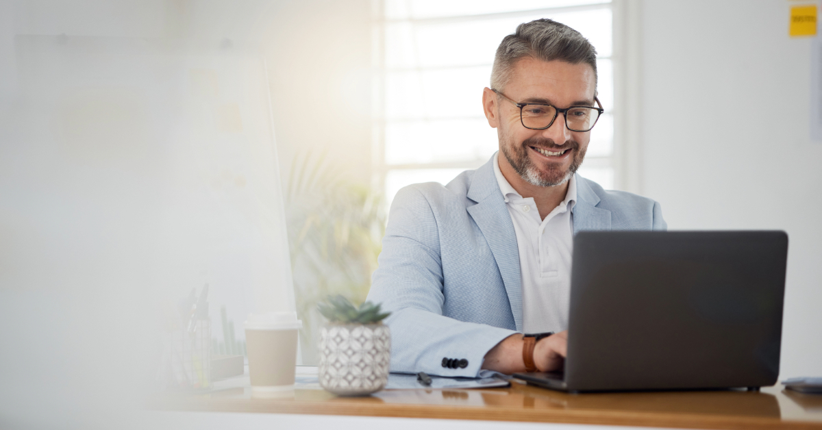 Un uomo sta usando un computer portatile per raggiungere il successo su Amazon FBA attraverso strategie collaudate, sorridendo visibilmente soddisfatto.