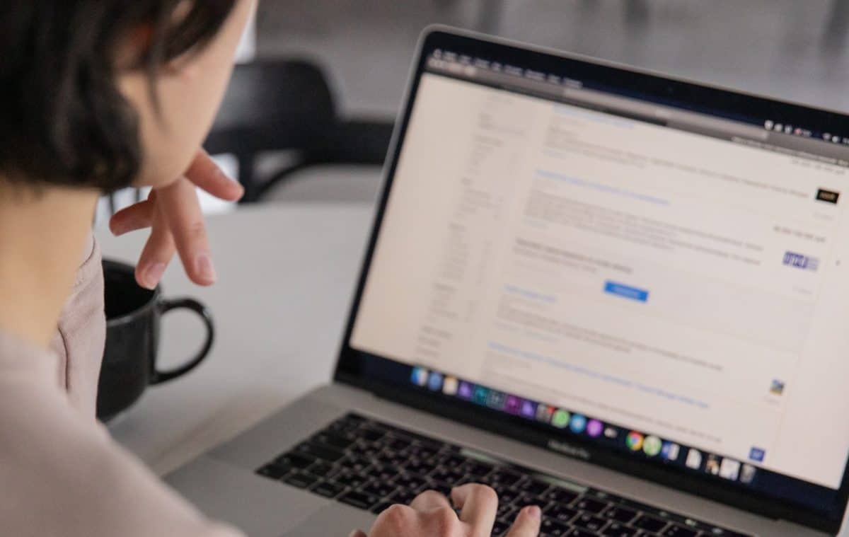 A woman is typing on a laptop computer, following the Ultimate Guide.