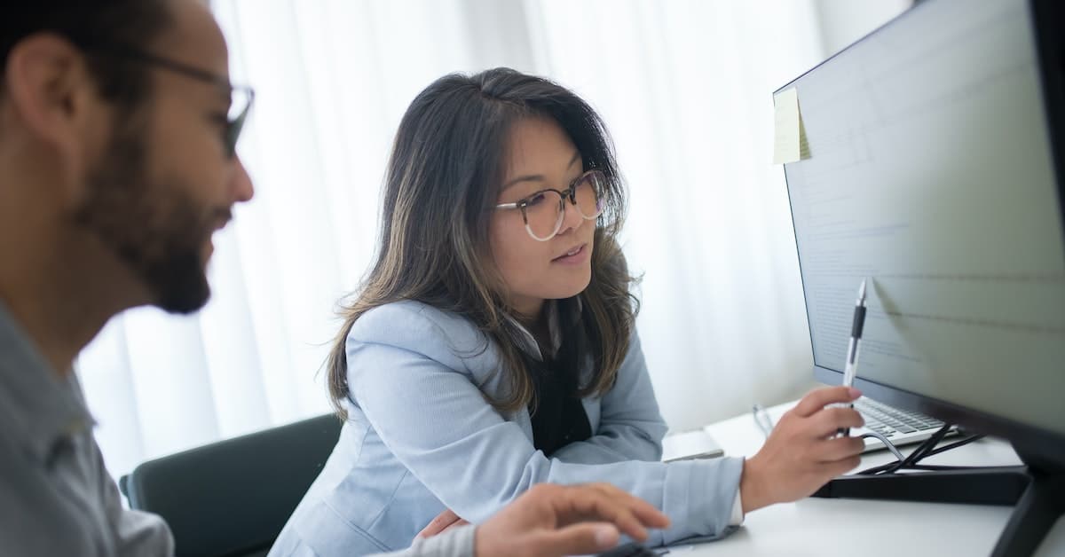 Two people focused on a computer screen.