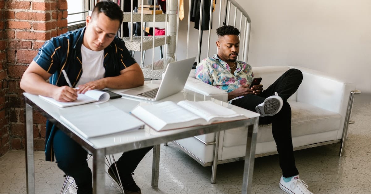 Two men working on laptops in an office, striving for online success through their web and SEO efforts.