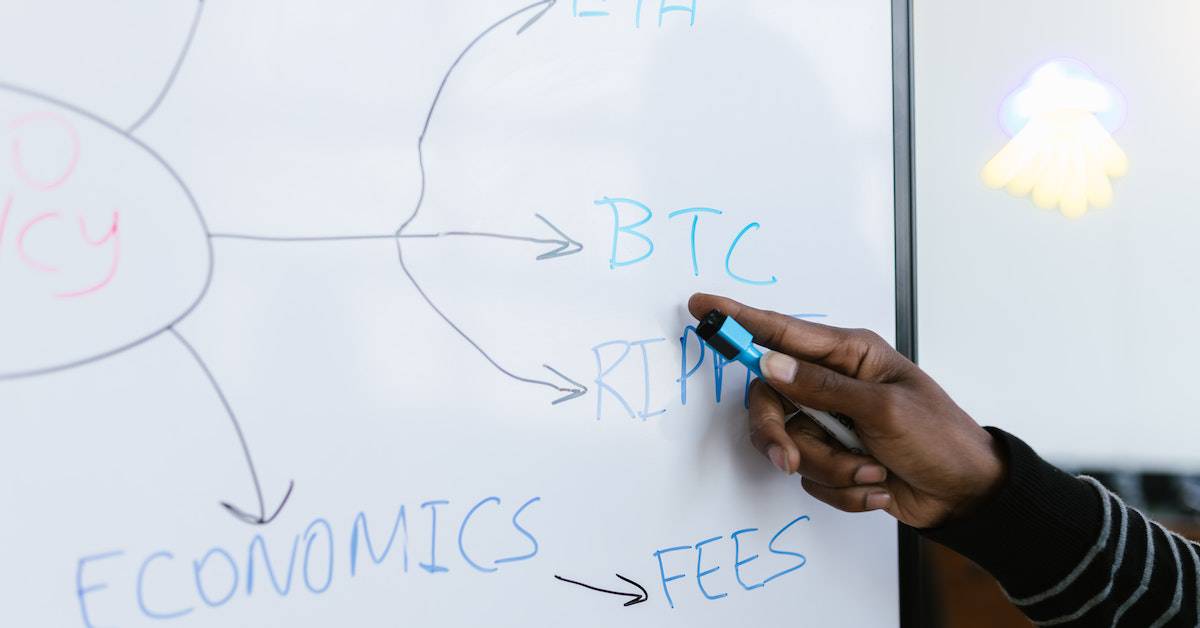 An individual writing on a whiteboard with a diagram, possibly discussing SEO strategies.
