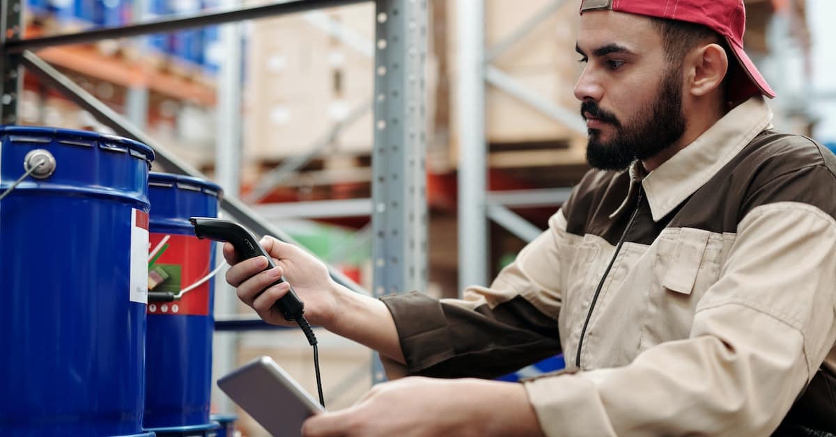 An employee is using a scanner in a warehouse for an eCommerce company.