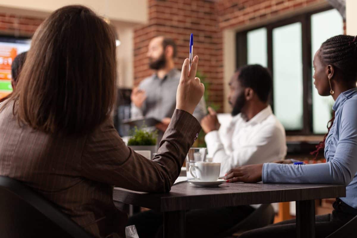A team of individuals sitting at a table in a conference room, exploring different management styles.