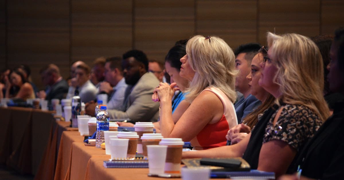 A group of people sitting at a long table, harnessing user-generated content.