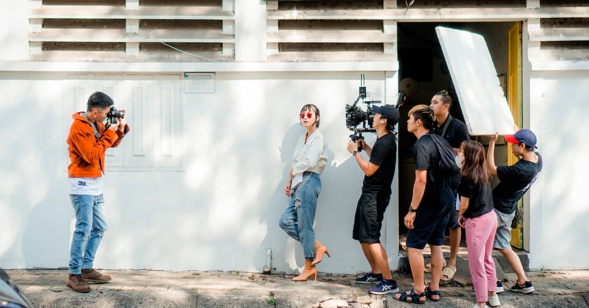 A group of people taking pictures in front of a building.