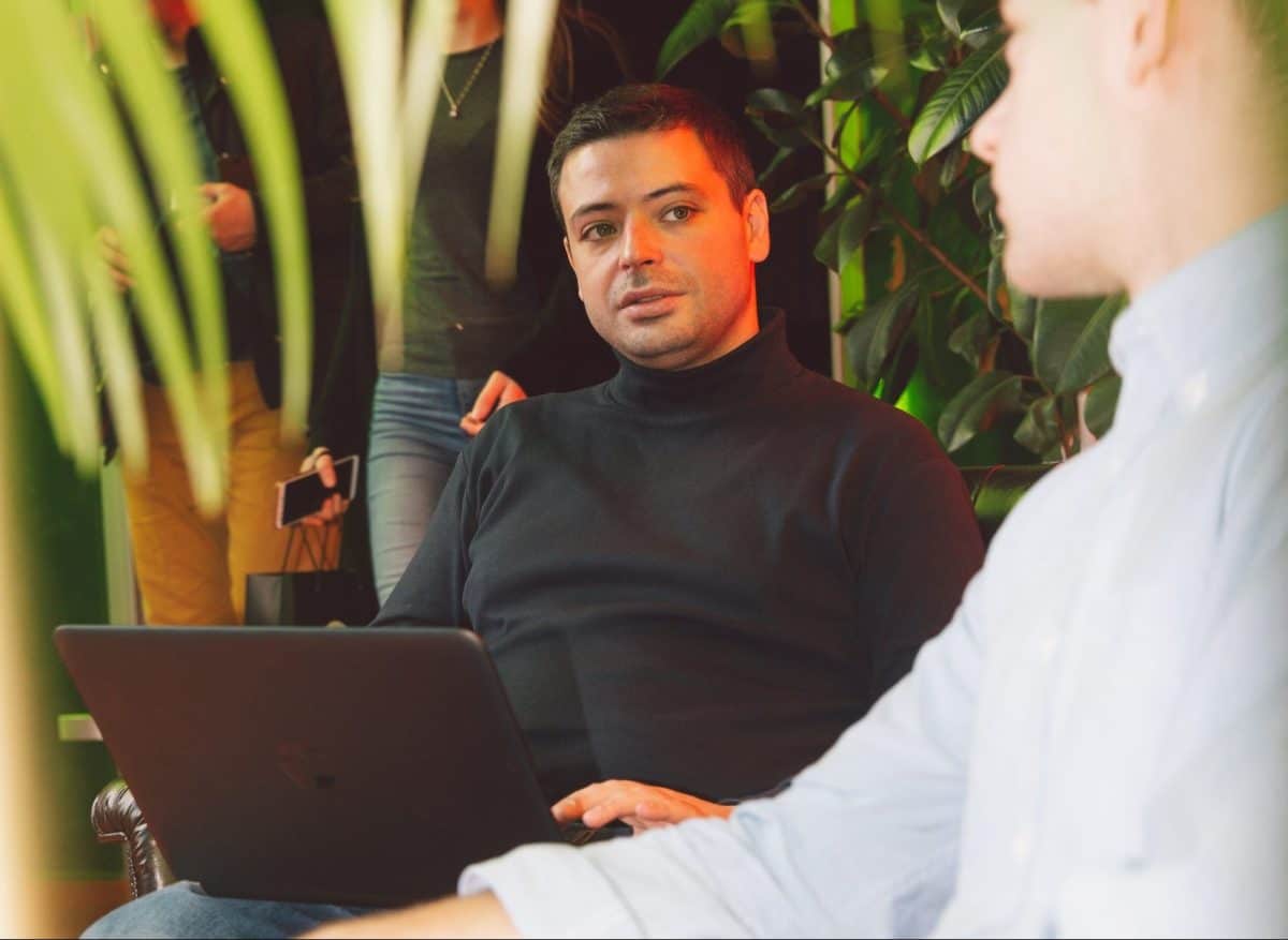 Two men sitting in front of a laptop, working on eCommerce development for online stores.