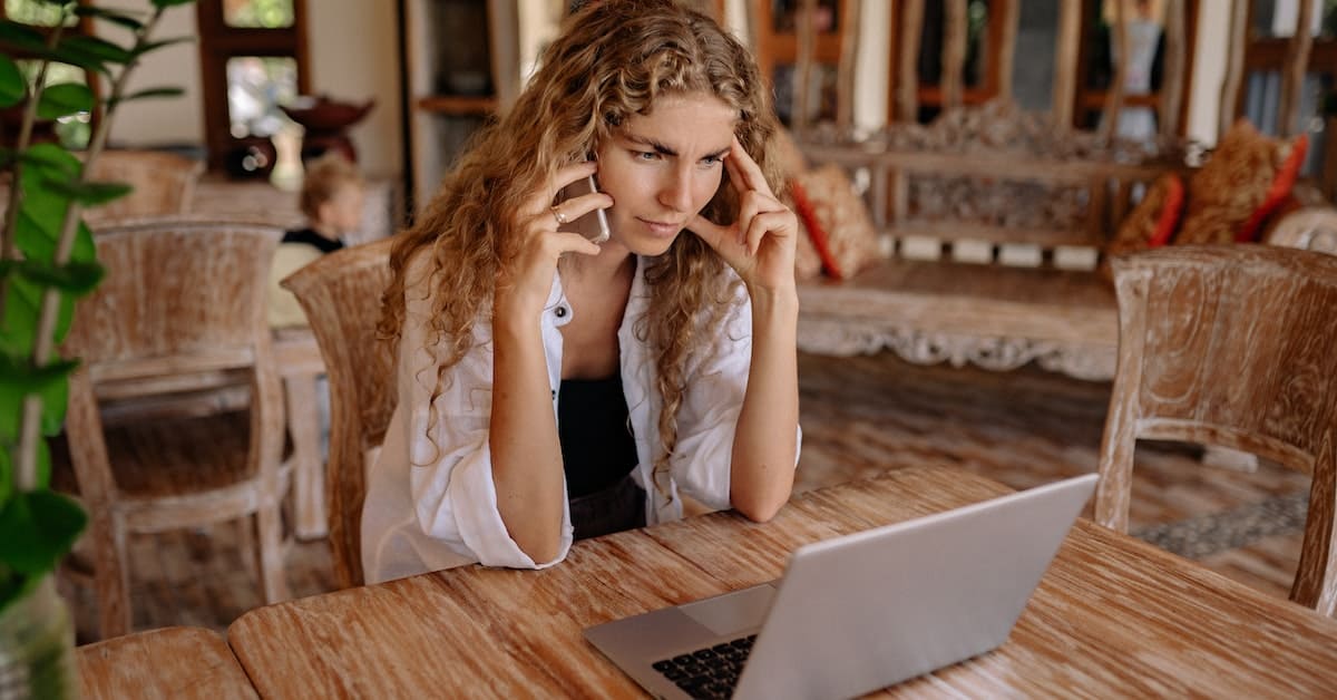 A woman sitting at a table with her laptop, showcasing her Ecommerce Success.