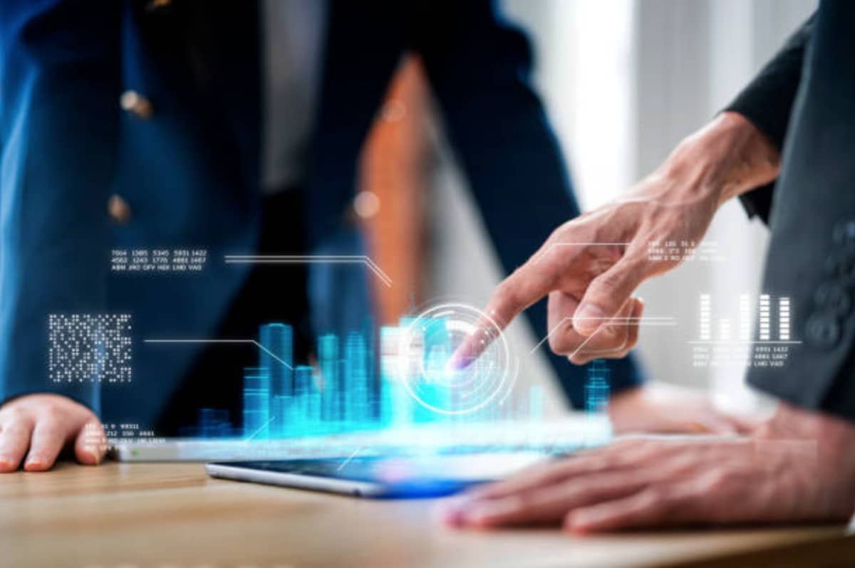 Business people navigating virtual realms and virtual economies, pointing at a computer screen.