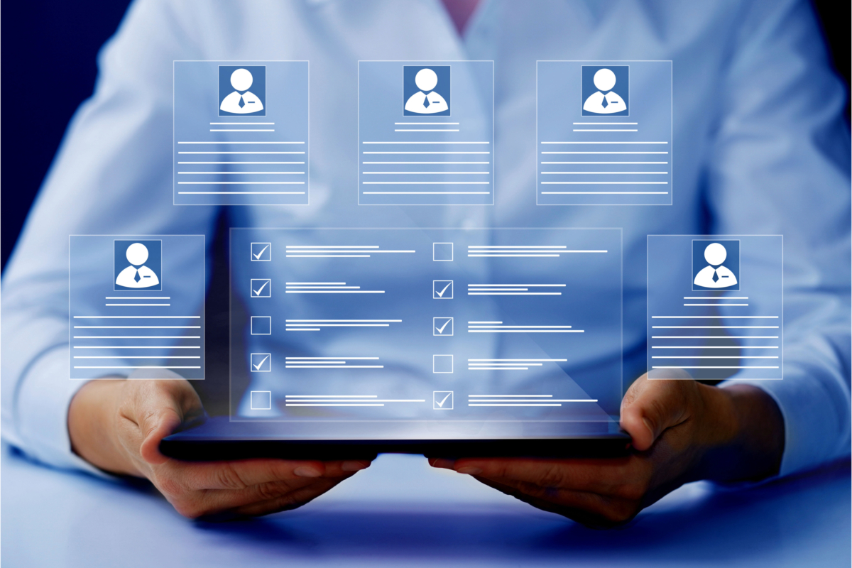 A person holds a tablet displaying multiple virtual profiles and checklists, rich with customer data. Various icons and data fields appear to be suspended in the air above the tablet's screen.