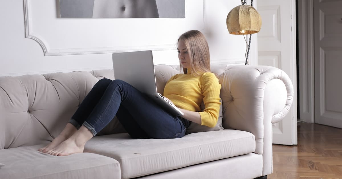 A young woman experiencing the psychology of e-commerce while using a laptop.