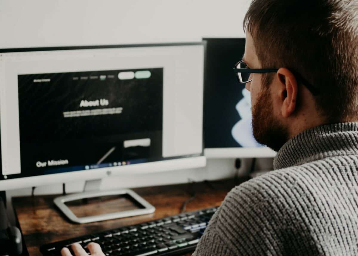 A man building a responsive website with Drupal on a computer screen.
