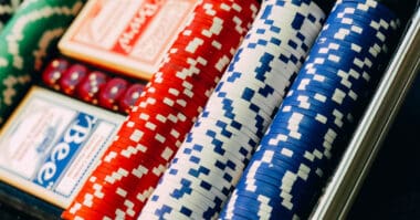 Stacks of colorful poker chips and playing cards inside an online casino case.