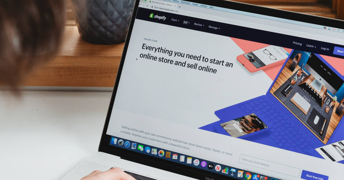 Person using a computer displaying the Shopify homepage, highlighting omnichannel marketing features for starting an online store.