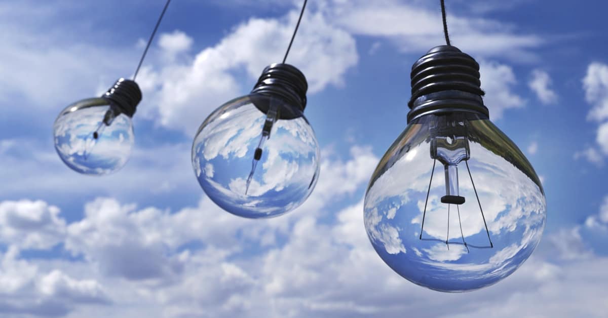 Three hanging light bulbs, both stylish and energy efficient, reflect a blue sky with clouds, creating a serene ambiance in your home.