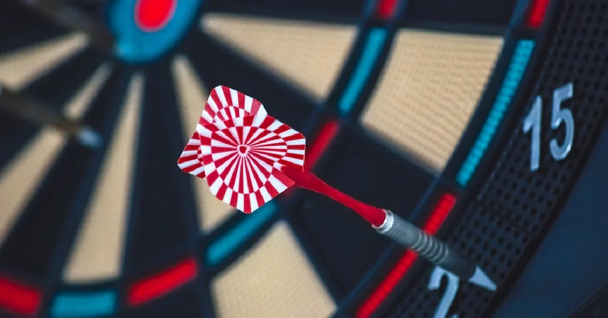 Close-up of a dart embedded in the bullseye on a dartboard, with the numbers 15 and 25 visible on the side, much like crafting effective strategies for generating high-quality Forex leads.