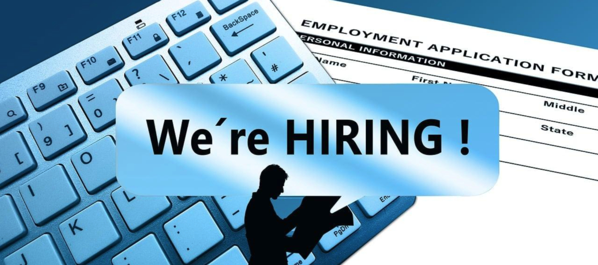 A keyboard and employment application form in the background with a blue speech bubble in the foreground that says, "We're HIRING!" and a silhouette of a person reading a document. Discover part-time jobs Singapore offering flexibility and growth opportunities!