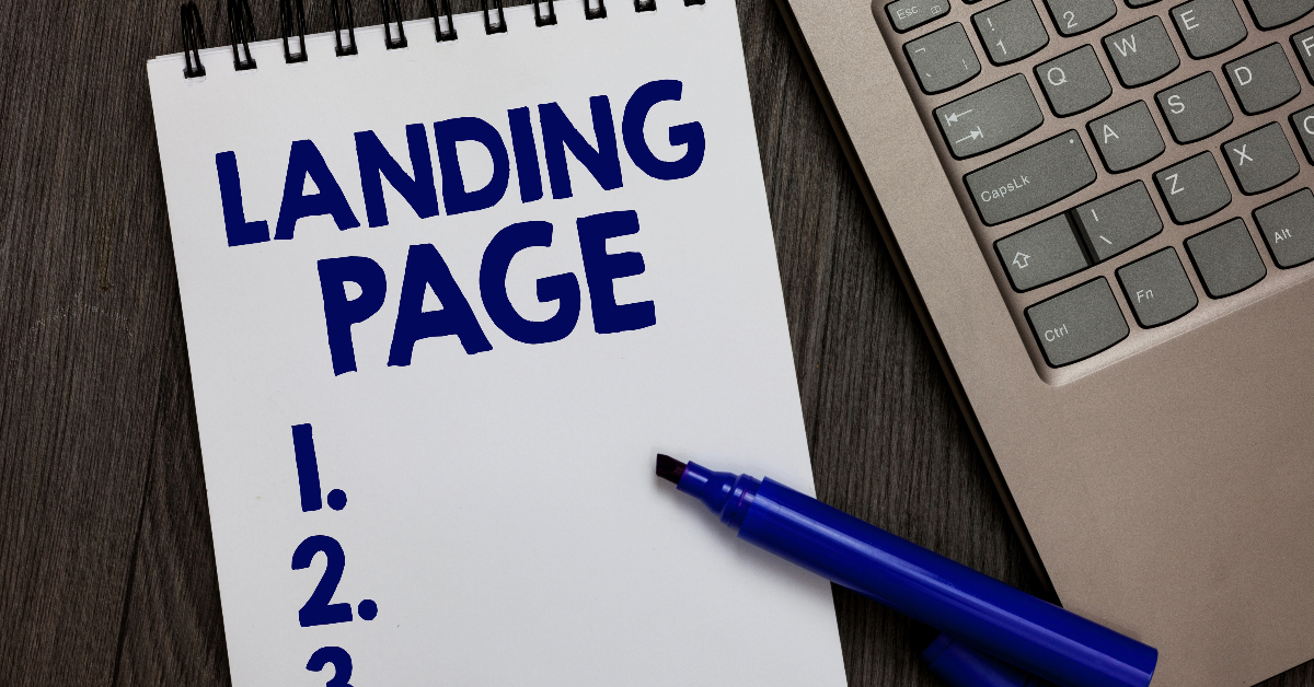 A notepad with the words "Landing Page" written at the top, next to a blue marker and a laptop keyboard, ready for SEO Optimization strategies.