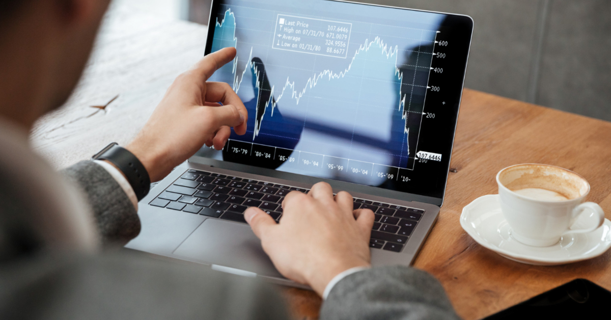 A person analyzing a financial chart on a laptop with a cappuccino on the table beside them, delving into the complexities of options trading.