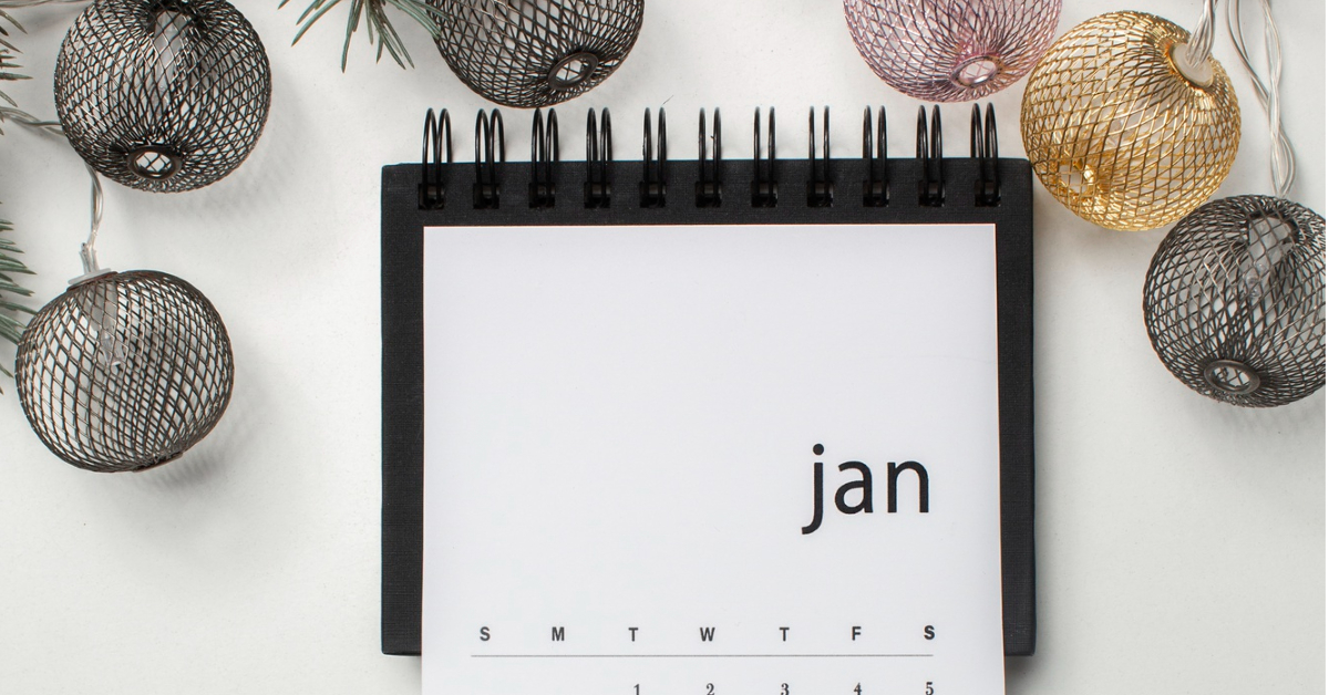 A spiral-bound calendar open to January, surrounded by decorative wire ornaments and pine branches, sets the scene for going all in on Dry January.