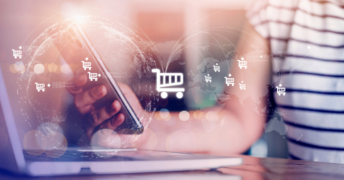 A person uses a smartphone and laptop with a global map and shopping cart icons overlay, symbolizing online shopping and e-commerce channels across multiple locations.