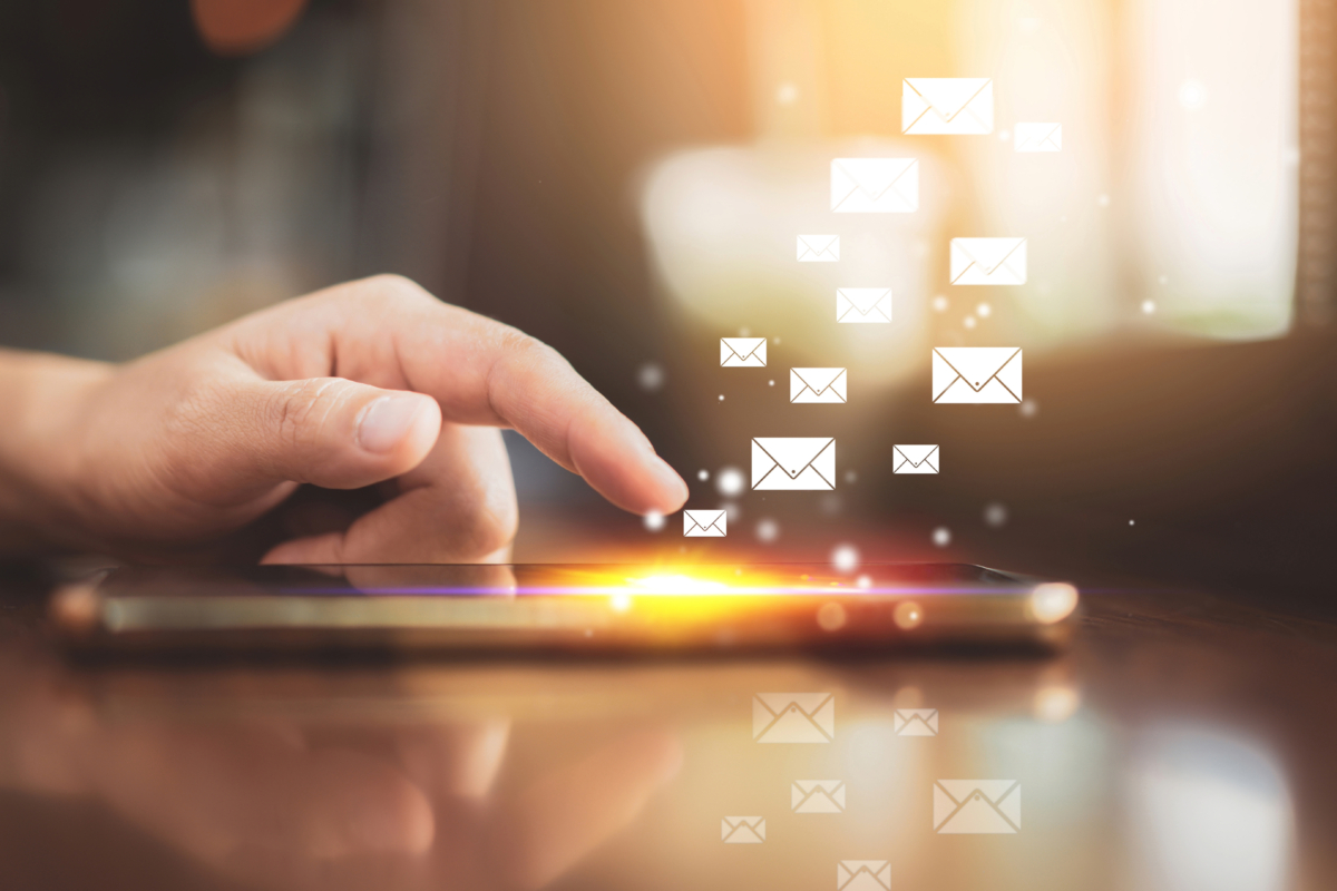 A person's hand touches a smartphone screen, with email icons floating upwards, symbolizing sending or receiving emails, enhanced by sleek gradients that elevate the overall email design.