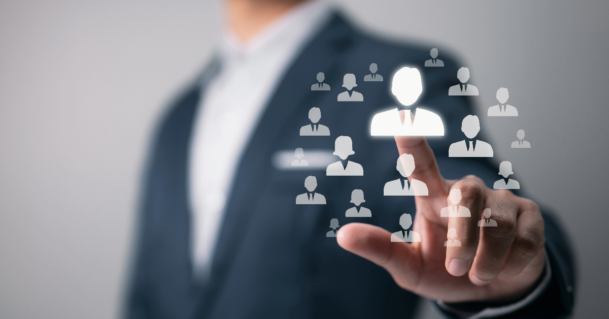 A businessman's hand is touching a group of people to improve customer segmentation using machine learning.