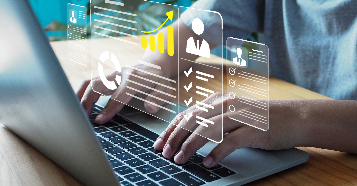 A job candidate typing on a laptop with graphs on it.