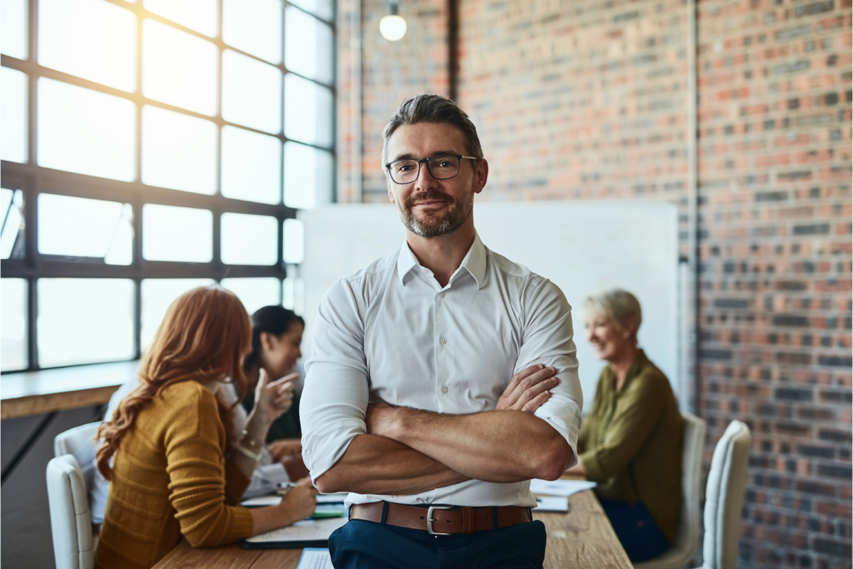 A man cultivating leadership skills in front of a group of people in an office in the ecommerce industry.