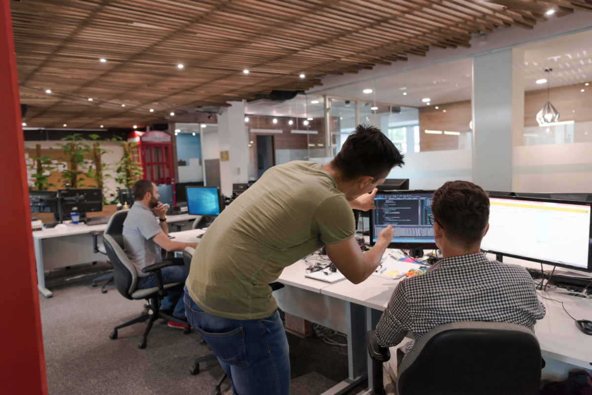 A group of people working on computers in an office, specializing in Magento development services.
