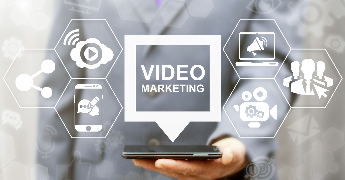 An expert man holding a phone displaying the keywords "video marketing" during a successful campaign.