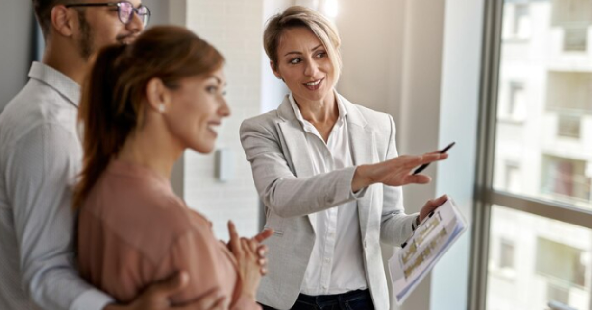 A successful business group standing in front of a real estate window.