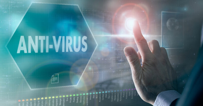 A man is expertly touching the word antivirus on a screen, performing virus removal and spyware removal with precision.