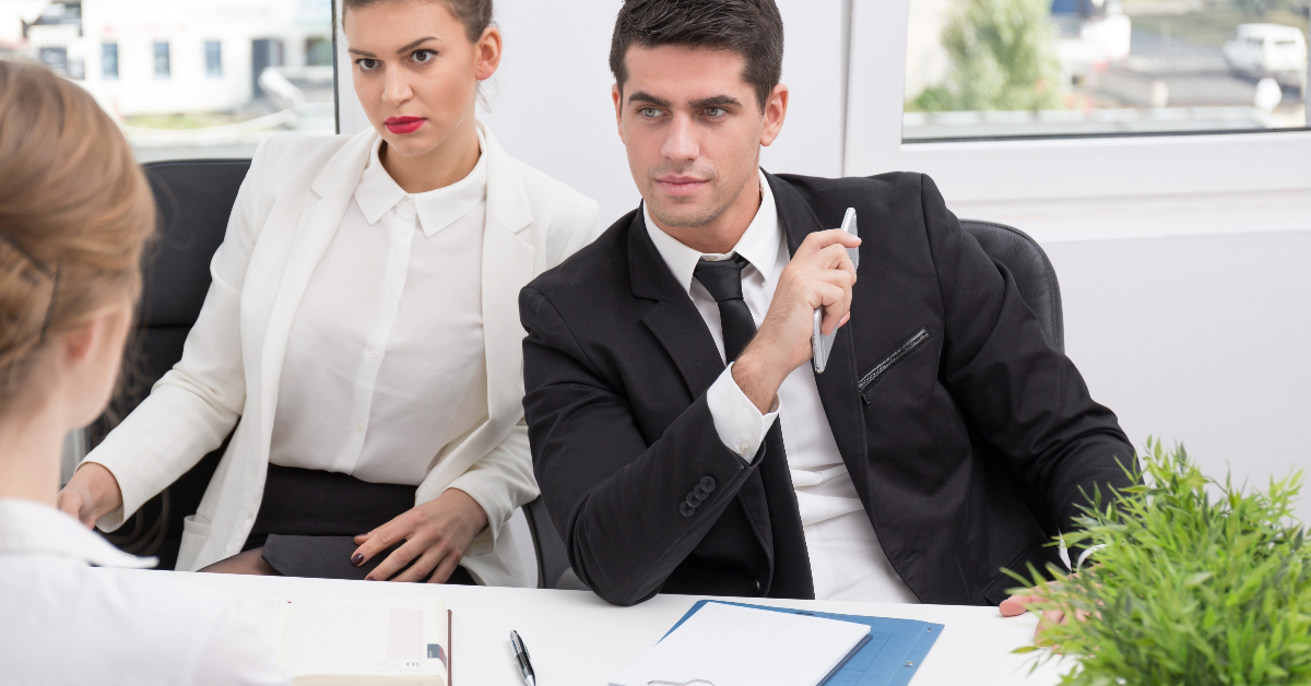 A man and woman are having a meeting in an office to discuss psychometric evaluation and hiring procedures. They are going over the tests that will be used for the evaluation process.