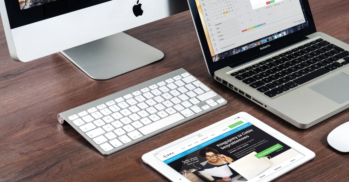 A laptop, tablet, mouse, and keyboard are placed on a desk to enhance one's tech skills and optimize their use of keywords for SEO purposes.