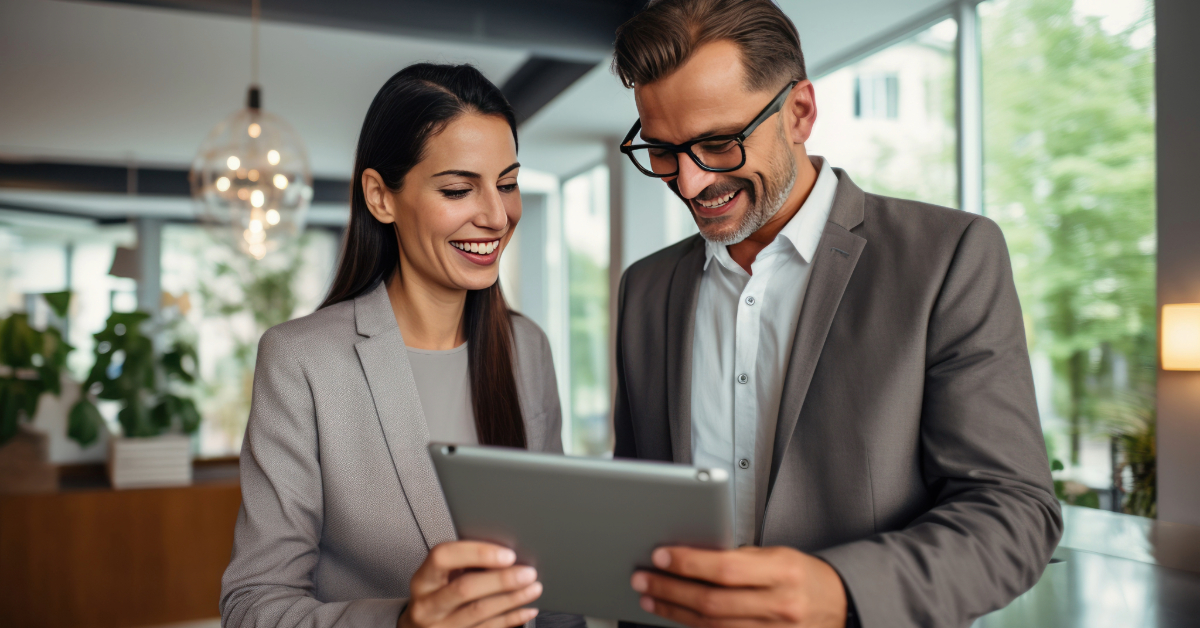 Two business people following a money trail on a tablet in an office.
