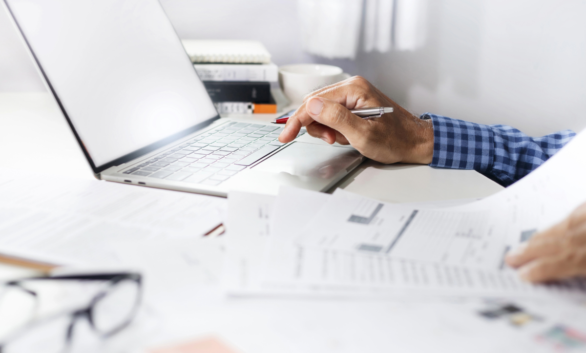 A man is managing the Shop's Product Catalog on a laptop at a desk during the holidays.