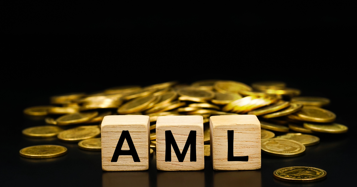 The word AML surrounded by gold coins on a black background in an illustration highlighting anti-money laundering protocols.