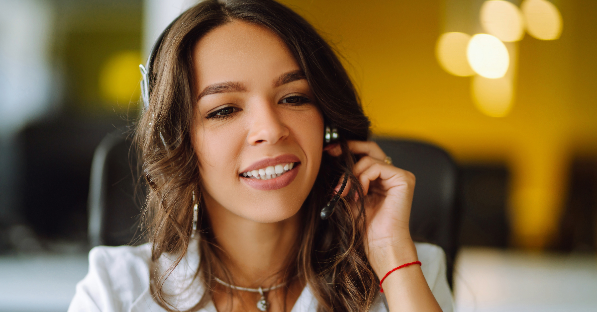 A woman wearing a headset in an office, tackling spam calls and navigating the evolving landscape of telemarketing.