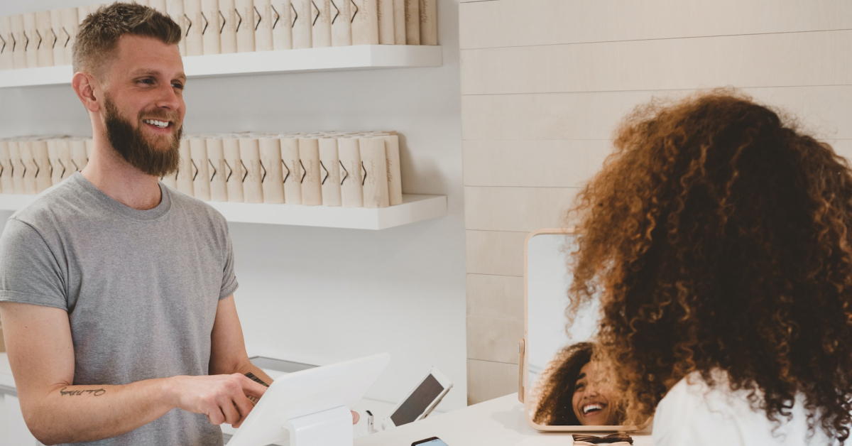A man is using a sales strategy to power-up the customer interaction in a hair salon.